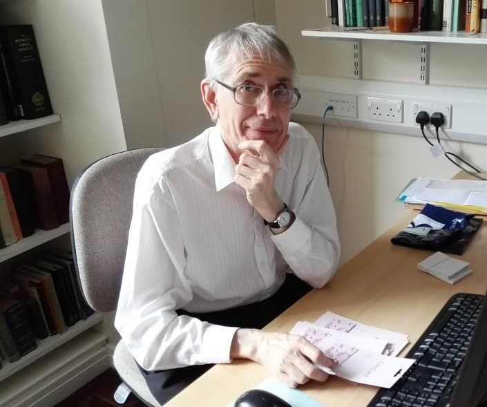 Photograph of Prof. Malcolm Heath sitting at his desk in his office at the University of Leeds.