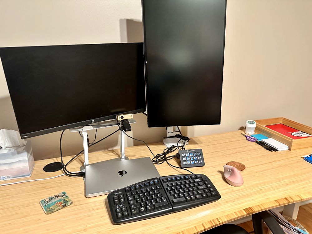 A very clean and tidy desk with computer screens, keyboard, mouse and few smaller items like pens and a notebook.