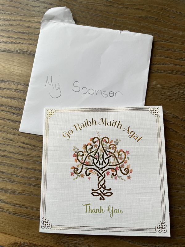 An envelope addressed to “my sponsor” with a card that says “Go raibh maith agat, thank you” on the front.