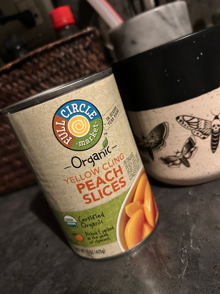 A can of chilled organic peaches on a counter