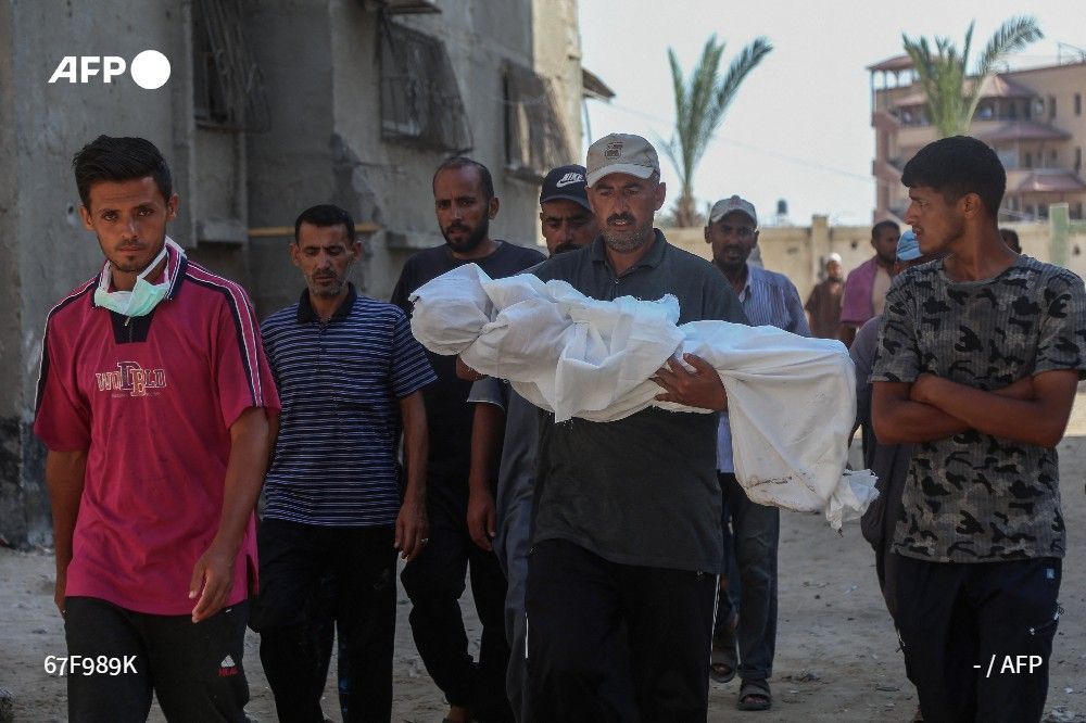 Mourners carry the shrouded body of Palestinian youth Abdul Jawad al-Ghalban, 14, who died of starvation, ahead of his burial at Nasser hospital in Khan Yunis in the southern Gaza Strip on July 22, 2025
