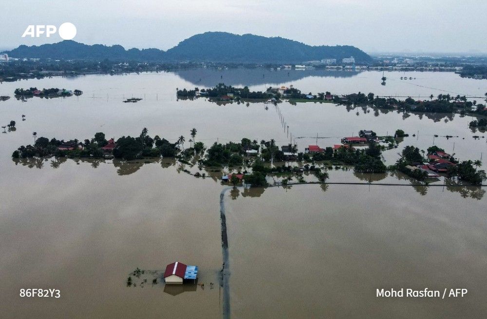 An aerial view shows homes surrounded by flood waters in Kangar in northern Malaysia's Perlis state on November 28, 2025, as flooding hit thousands of people in the region after days of heavy rain