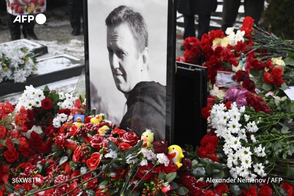 A portrait of Russian opposition leader Alexei Navalny at his grave at the Borisovo cemetery in Moscow on February 16, 2025, as people gather to mark the one-year anniversary of his death in an Arctic colony