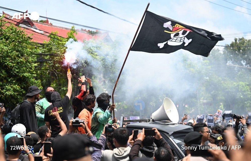 Protesters wave a pirate flag from the Japanese anime One Piece -- an internet trend used to criticise government policies -- during a demonstration outside Bali police station in Denpasar, on Indonesia's Bali island, on August 30, 2025
