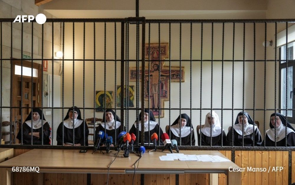 The eight former nuns sit behind a grille, which separates the nuns from visitors, as they give a press conference at the Santa Clara Monastery in Beldorado, northern Spain, on July 29, 2025.