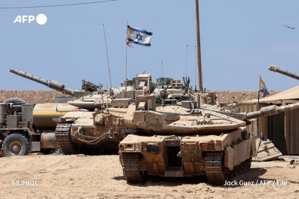 File photo shows Israeli troops deploying their tanks near the border fence with the Gaza Strip on August 1, 2025