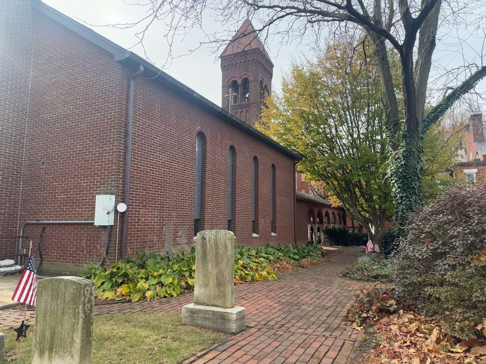 Image of a brick sidewalk and church on a fall day. 