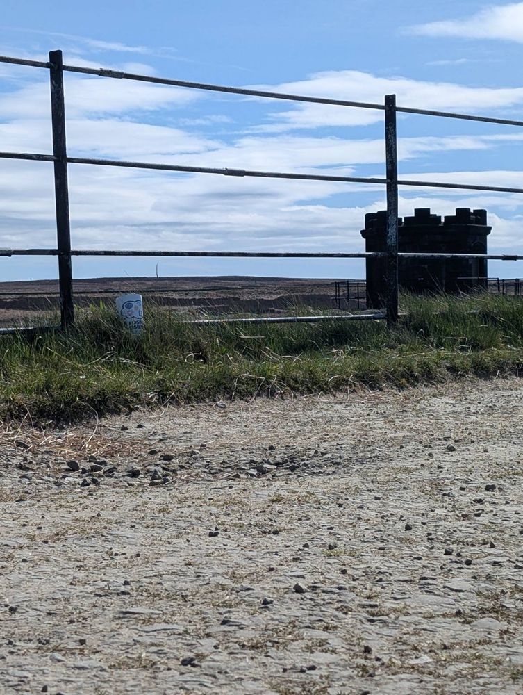A path, a fence, and some sort of structure. Where could this be?