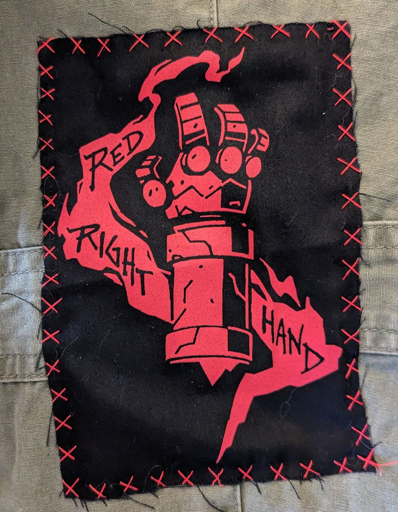 Screen printed fabric patch sewn on a jacket: Hellboy's arm with the text "Red Right Hand" 