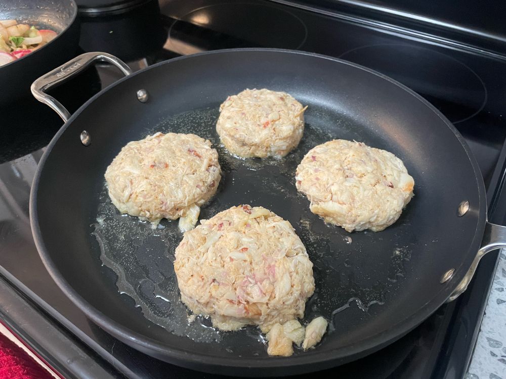crab cakes frying in a pan
