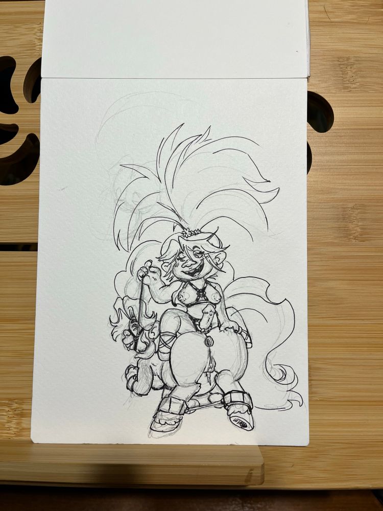 Poppy sitting on Delta Dawns back, pulling the head harness on Delta as displays the strap between her legs. Delta is dripping as her legs are open thanks to a bar and a butt plug