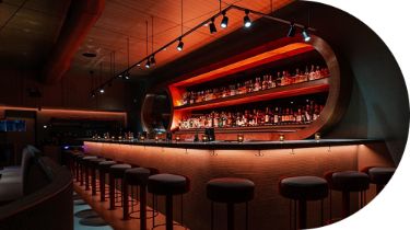 A curved bar lit with dark amber lights 