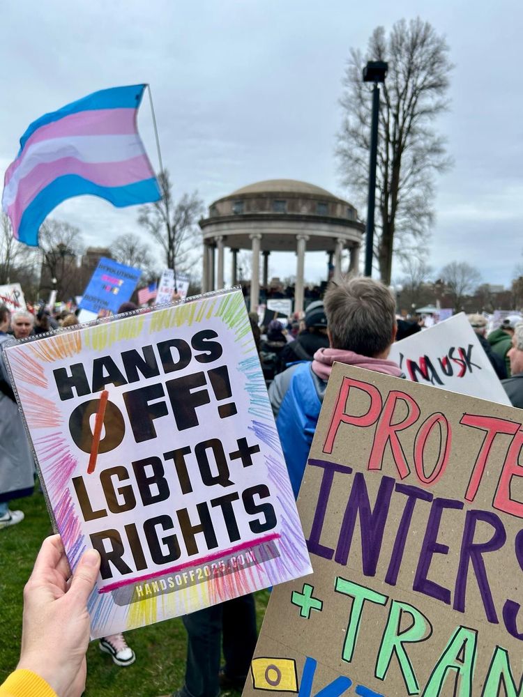 A picture of a sign that says hands off LGBTQ+ rights in front of the Parkman bandstand in Boston