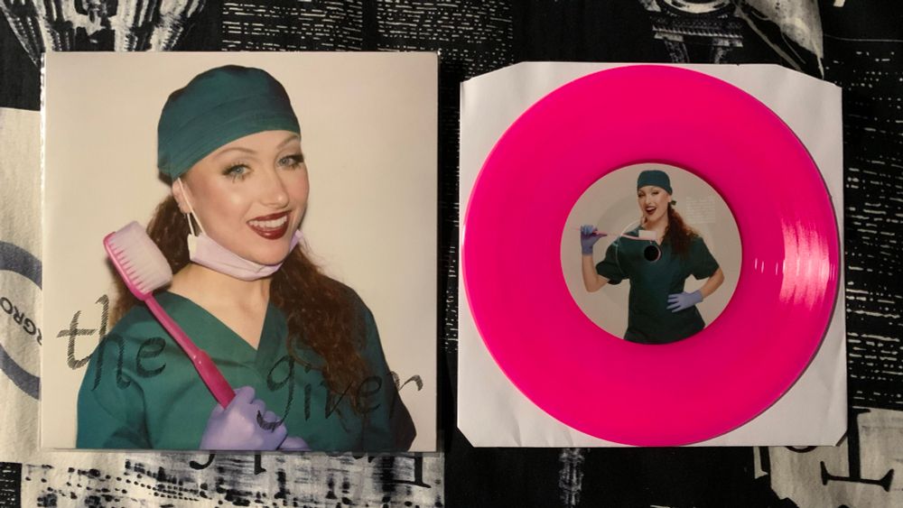 “The Giver” by Chappell Roan
dentist sleeve (Chappell dressed in scrubs with a face mask pulled below her chin while holding a big toothbrush) & pink vinyl