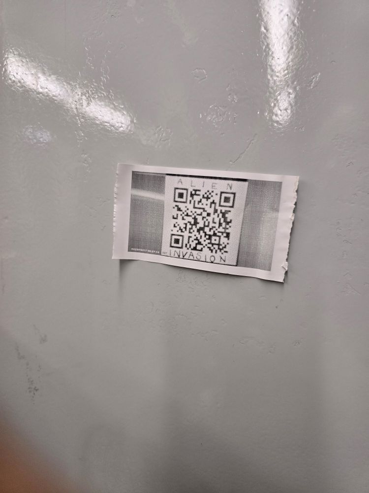 QR code on train wall with 'ALIEN INVASION" written above and beneath.