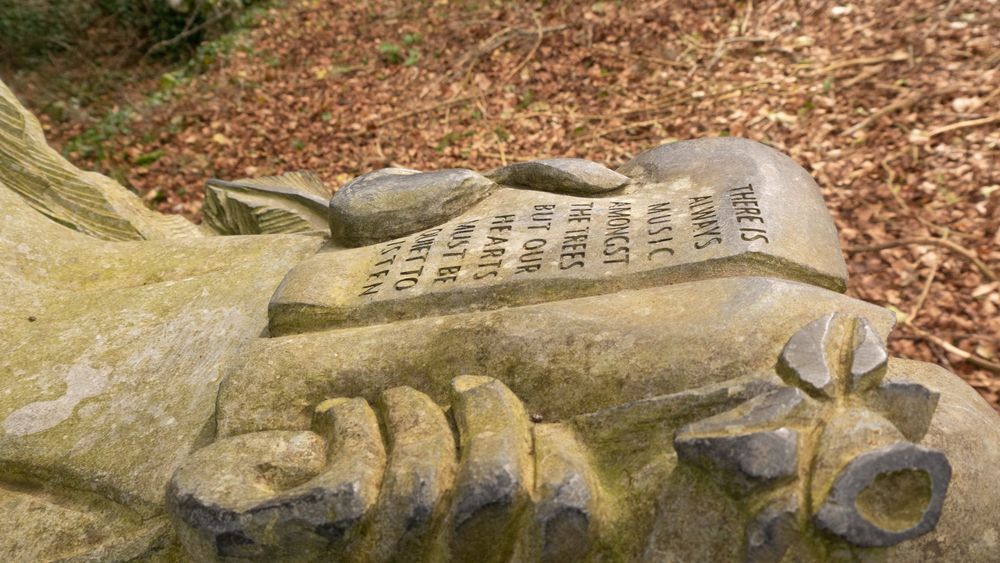 "There is always music amongst the trees in the garden, but our hearts must be very quiet to hear it." by  Minnie Aumonier. 

Poem scroll on held by 'Spirit of the Forest' sculpture, in Ballybeg woods, County Clare. Ireland. 
