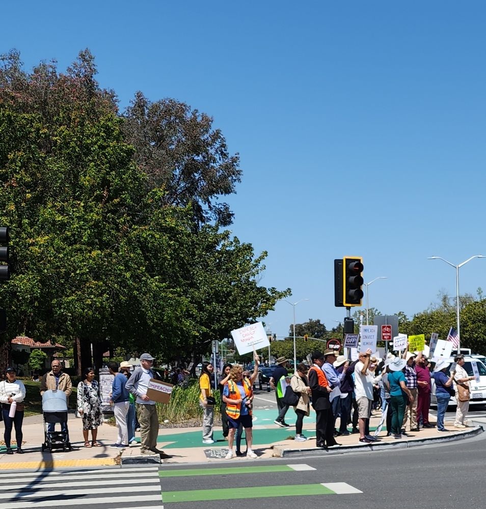 People holding protest signs on street corner.