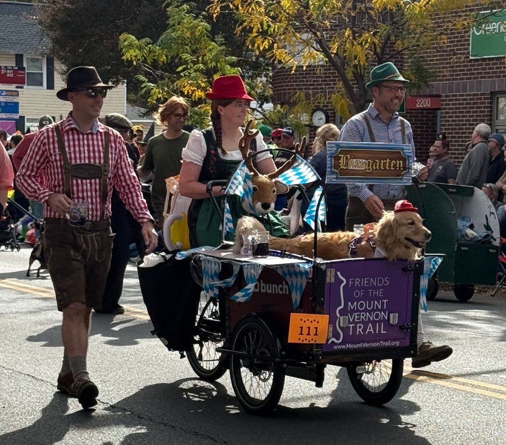 Friends of the Mount Vernon Trail's Bunch Bike BarkGarten - A golden Retriever in a Bunch Bike with three lederhosen clad escorts (and a deer, I think!)