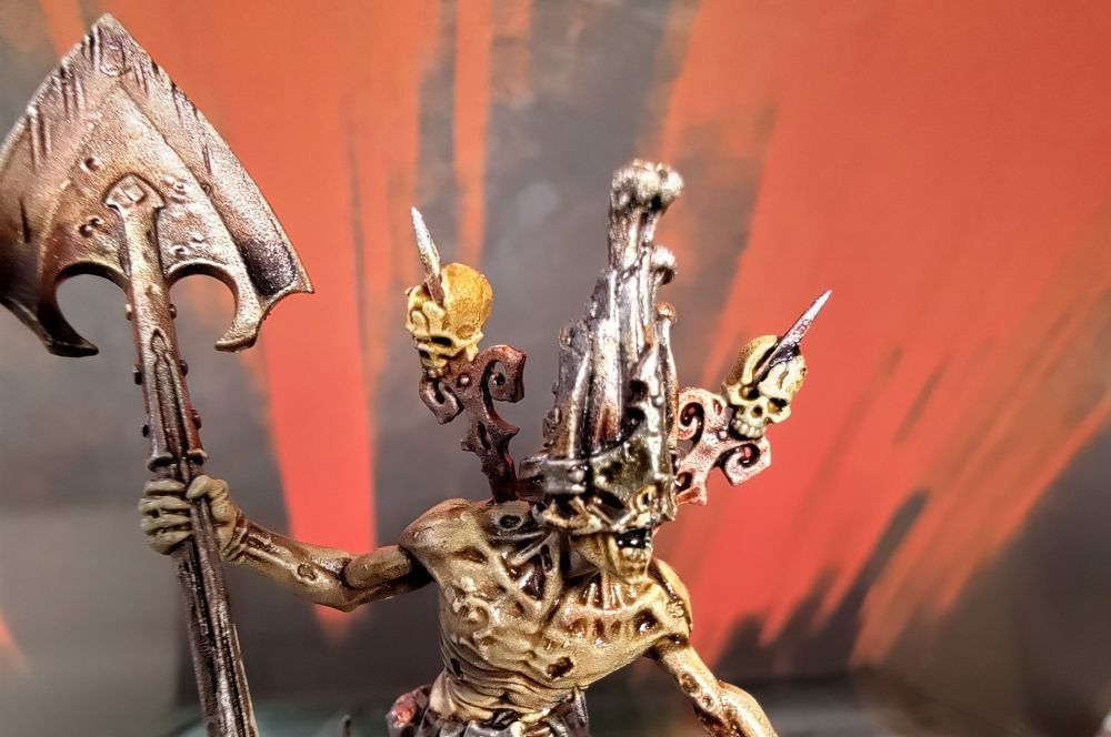 Close up of the mask and implanted trophy rack on the figure. The trophy rack resembles wrought iron gates from a graveyard, as does the mask being of equal parts coffin wood and wrought iron covering the monsters eyes