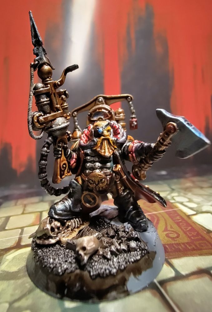 Dagnai Holdenstock miniature from Warhammer Quest Cursed City. Ab eyepatched fantasy dwarf in a black jacket with gold plated equipment, a face mask in the shape of a beard, connected to an intricate gilted backpack, welding a gas powered harpoon launcher and a fancy axe. Photographed from the front 