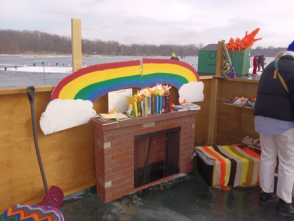 Art shanties on Lake Harriet, banned books station with rainbow over a fake fireplace