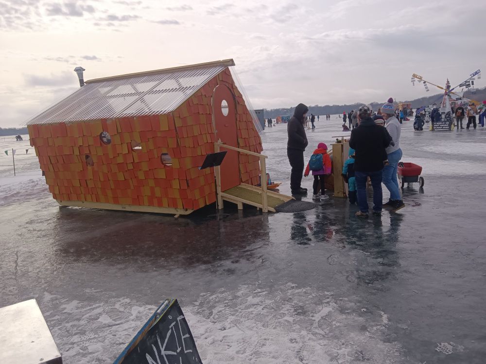 Art shanties on Lake Harriet, small orange cottage