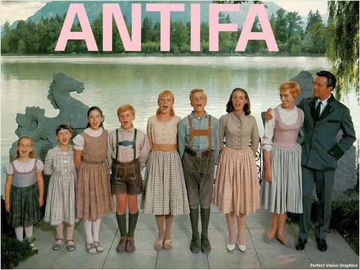 The Sound of Music cast standing side by side in front of a lake with the word Antifa over them in all caps
