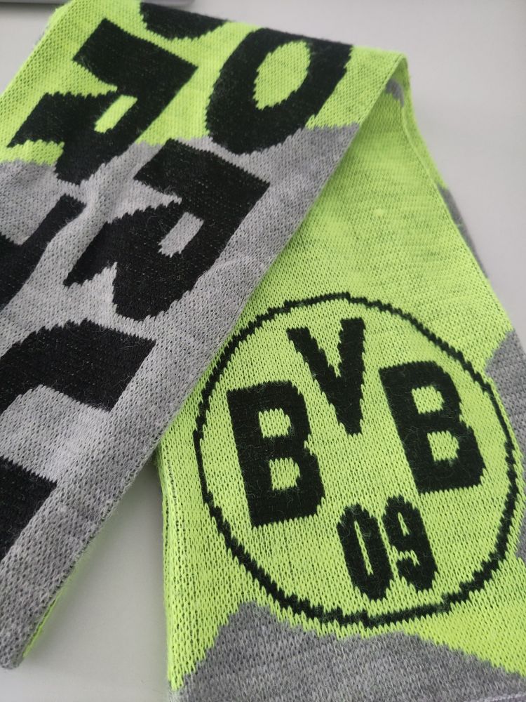 Schal mit schwarzem BVB Logo und schwarzer Aufschrift "Borussia Dortmund" auf neon gelben und grauen Hintergrund.