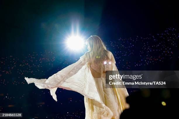 a photo of Taylor Swift from the folklore set of the Eras tour in a cream dress, photographed from behind. Emma McIntyre, Getty Images