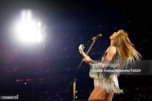 a profile photo of Taylor Swift from the fearless set of the Eras tour in a salt and pepper fringe dress playing the guitar. Emma McIntyre, Getty Images