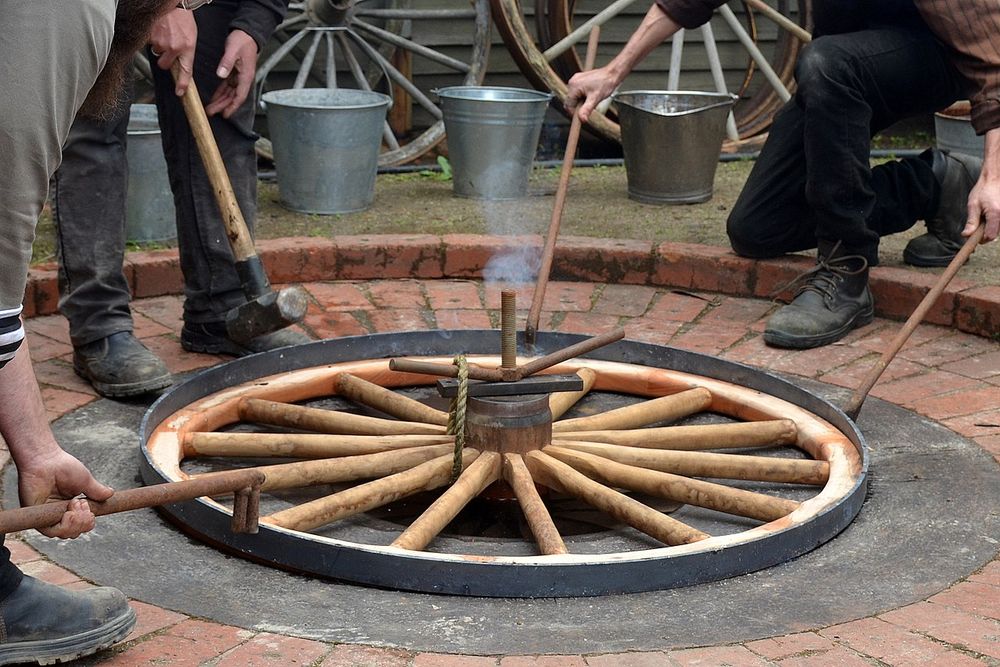 A hot tyring (or hot tiring in US English) demonstration at the wheelwrights at Sovereign Hill. A metal tyre (tire) is heated to expand it, positioned around the wheel and then cooled to contract it until it fits the wheel tightly. Sovereign Hill, Ballarat, Victoria, Australia Note: For Sovereign Hill Museums Association and for Sovereign Hill staff and volunteers, the attribution specified in the copyright is not required. Attribution is not required from any person included in this photo.