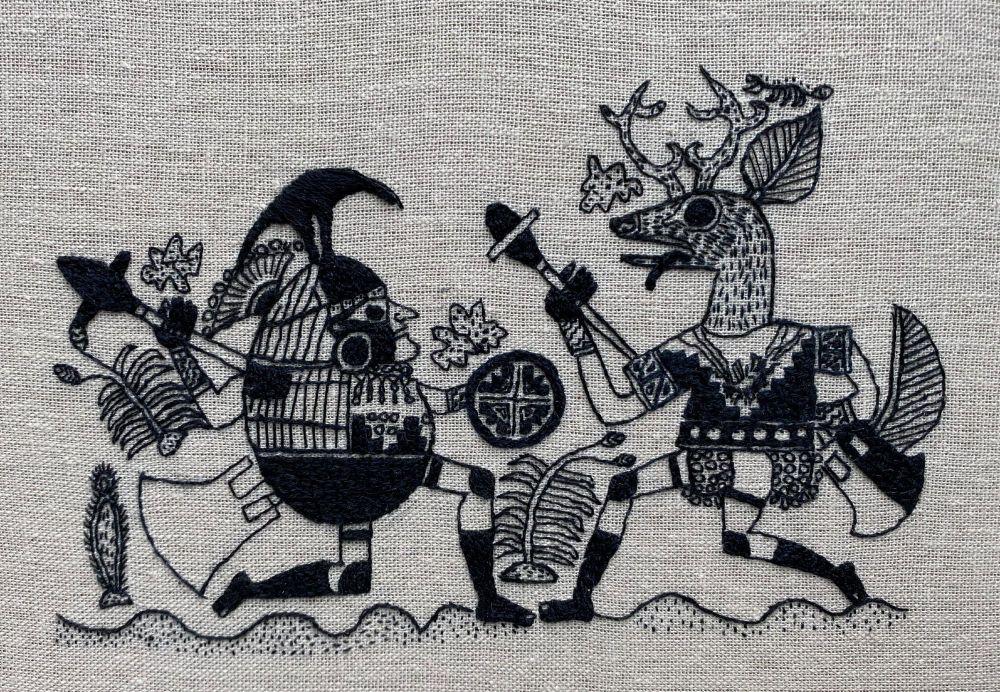 Dark thread on a beige cloth background:  a round-bodied man in knee-socks and a bizarre crested helmet holds a sword and metal club or mace, while a deer-headed hominid with knee-socks and armor battles him in profile view,  Behind them are various desert plants, and a wavy line suggests they stand on sand dunes.