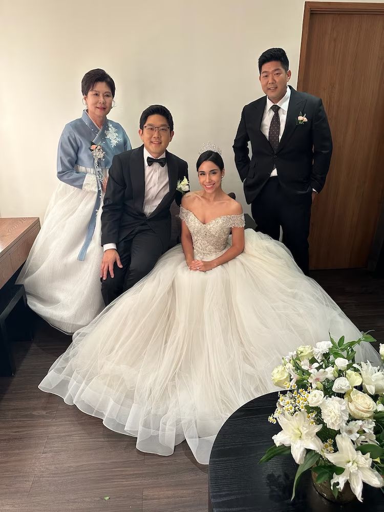 A lovely lady in a white wedding dress, a groom in tuxedo, and behind this is Will, their cousin, who is in detention.
"Will Kim (right) with family members.
Courtesy of the Kim family"