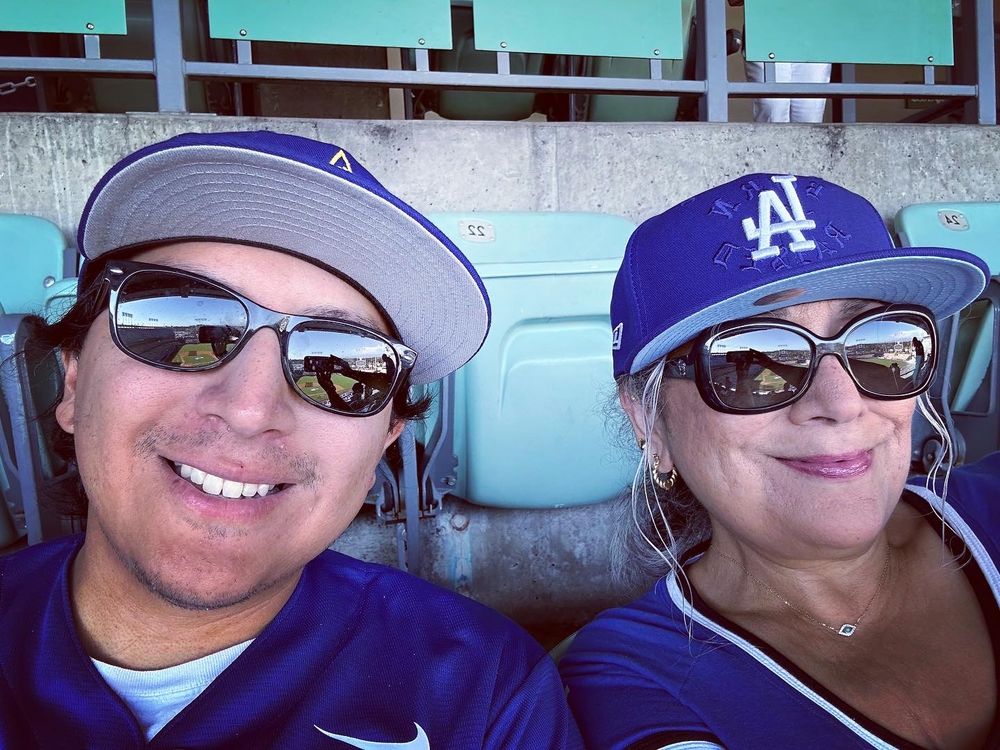 Son & Mother in Dodgers t-shirts and hats seated at the Dodger game.