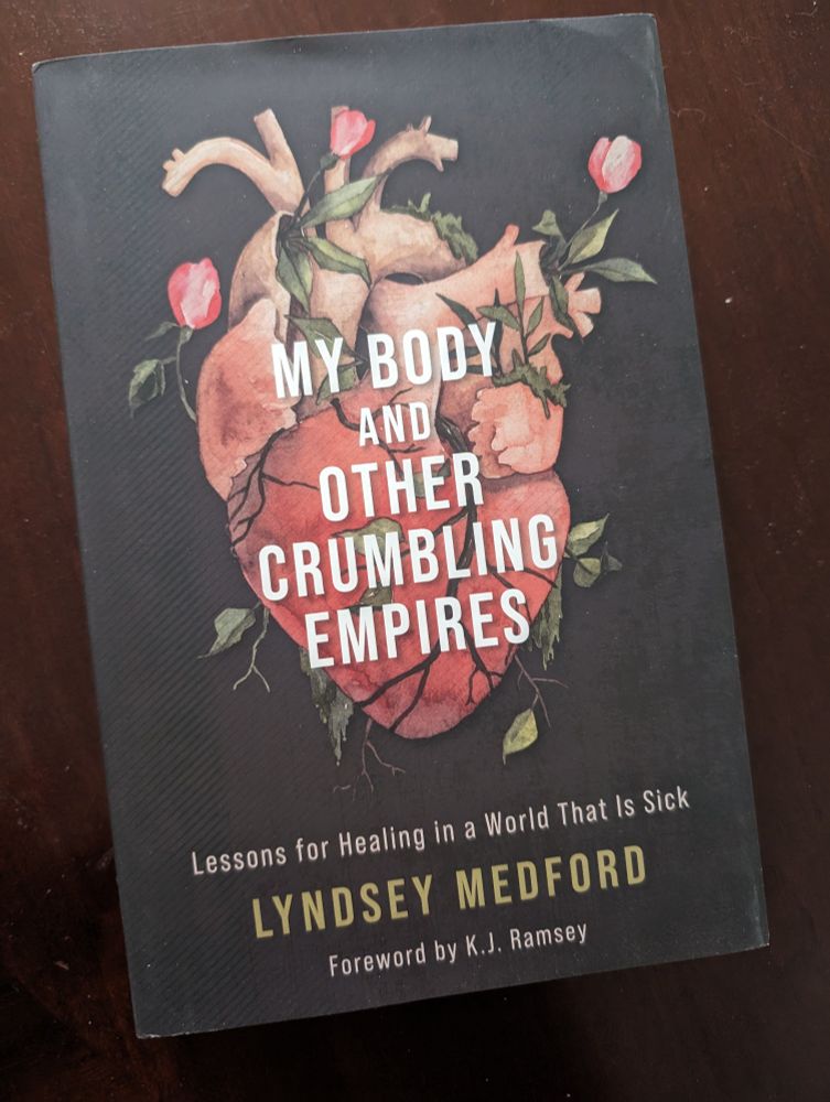 A copy of Lyndsey Medford's "My Body and Other Crumbling Empires: Lessons for Healing in a World That is Sick" on a wood background 