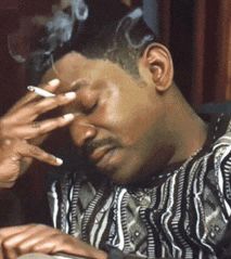 Man, holding a cigarette, pensive.