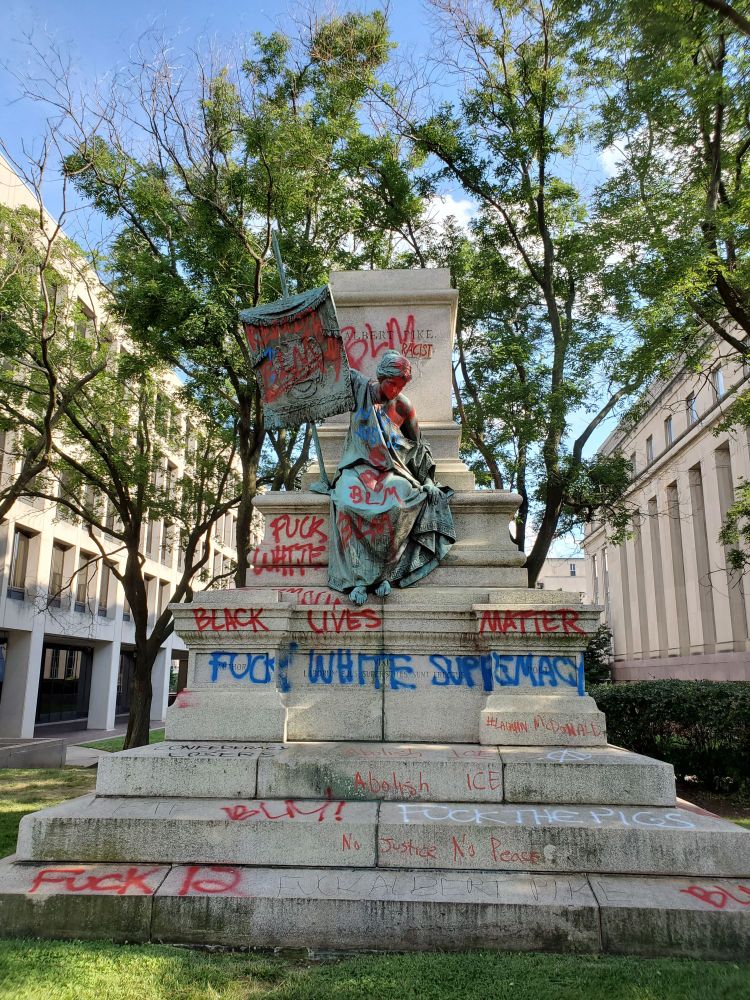The pedestal to Albert Pike (without statue), covered in graffiti that labels him racist and says things like Fuck White Supremacy, Fuck 12, Black Lives Matter.