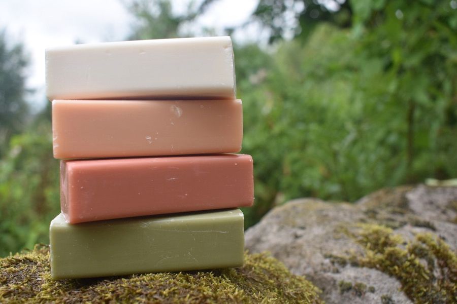 Stack of soap bars on a mossy stone wall