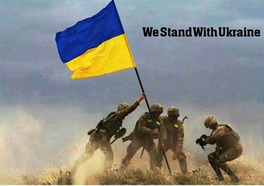 Ukrainian soldiers raise a flag with the inscription « We stand with Ukraine »