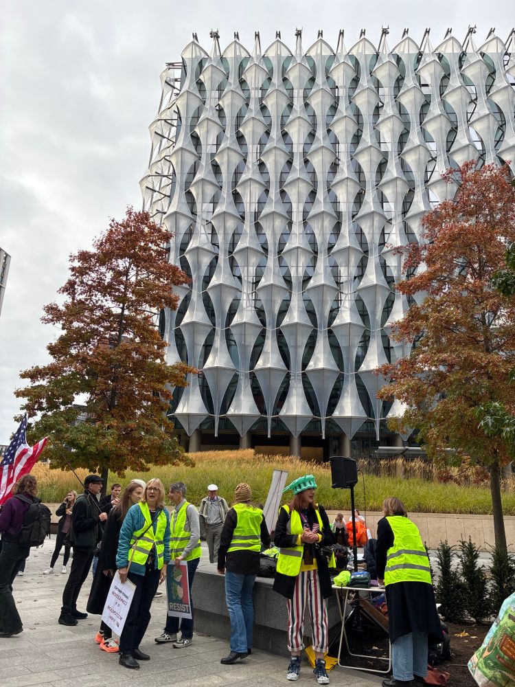 People gathering for No Tyrants protest at the American Embassy in London. Very modern, and huge, embassy building in the background.