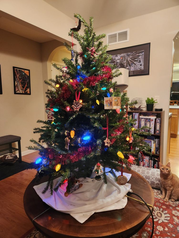 A small decorated Christmas tree standing as a table centerpiece. 