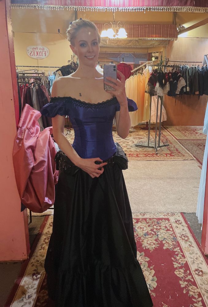 Structured, shiny purple blouse with a black floor length skirt - historically influenced shapes, these were borrowed from a vendor at Dicken’s Fair.