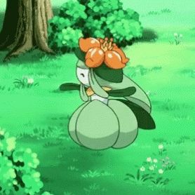 a green pokemon with a flower on its head is sitting in the grass .