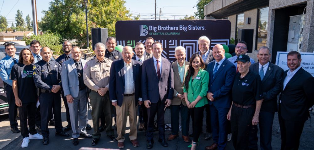 A photo of community leaders in Central California standing in front of a step and repeat that says Big Brothers Big Sisters of Central California during a press conference.