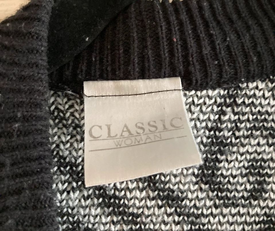 A black and white cardigan with a faded label reading Classic Woman