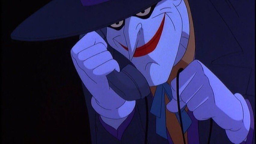 The Joker holding a phone mischievously