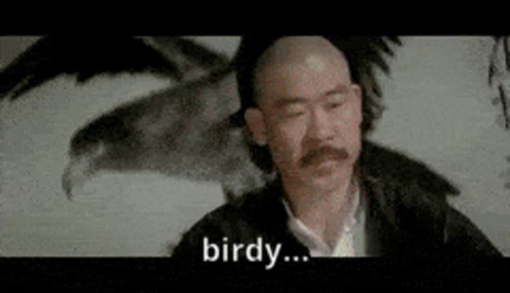 a bald man with a mustache is standing in front of a painting of an eagle and says `` birdy '' .