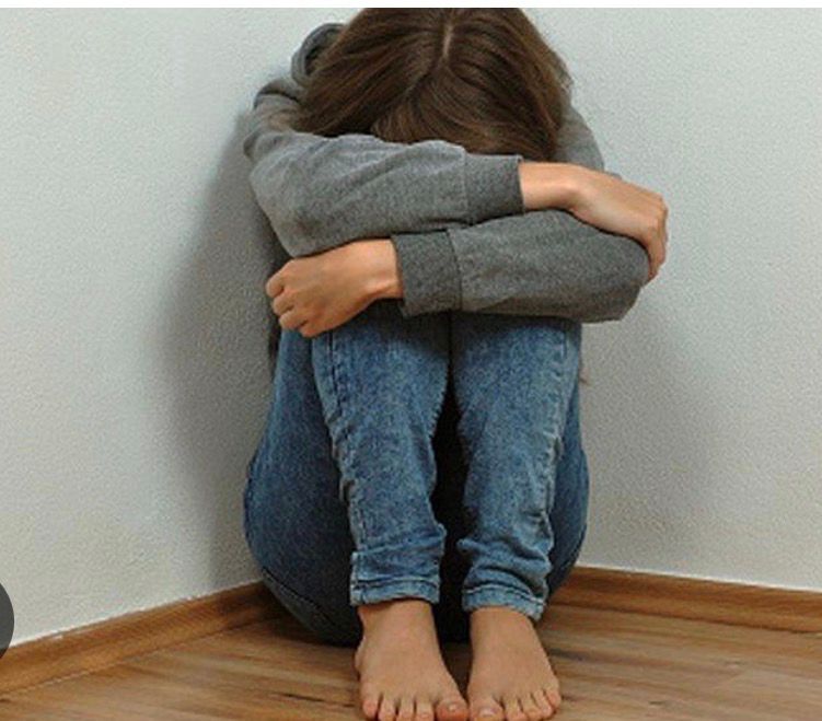 Child in a corner with their head down. 