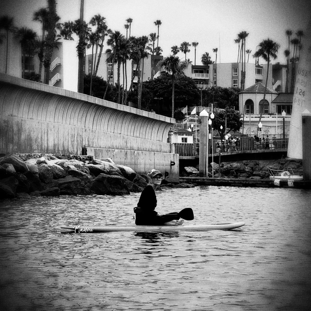 Photo of a woman sitting on her paddleboard. Photo taken in California.