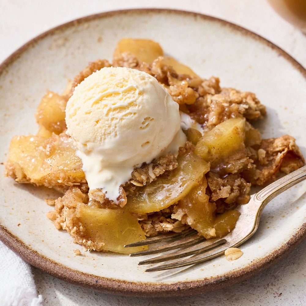 a plate of apple crisp with a scoop of french vanilla ice cream on top
